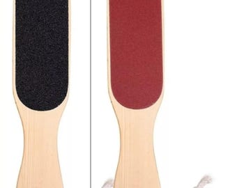 May include: Two foot files with light wood handles and hanging ropes. One file has a black abrasive surface, the other has a red abrasive surface. Each file is 5.6 cm wide and 23.4 cm long, as indicated by the measurement lines and text.