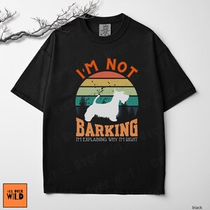 May include: A black short-sleeve t-shirt featuring a graphic of a white dog silhouette against a retro sunset background. The text reads I'M NOT BARKING I'M EXPLAINING WHY I'M RIGHT in orange and white lettering, with a forest silhouette below.