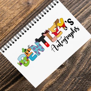 May include: A spiral-bound notebook with the words "BEN'S Autographs" on the cover. The letters are designed with cartoon character themes, including a green and blue letter "B", a purple and blue letter "E", and a black and red letter "N".