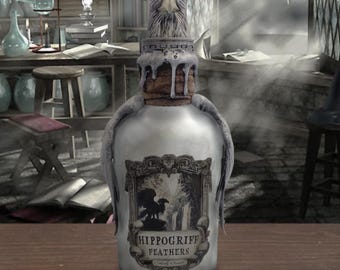 May include: A silver bottle with a sculpted hippogriff head stopper. The bottle has a label that reads "Hippogriff Feathers".