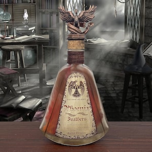 Puede incluir: Una botella decorativa con una tapa de fénix de bronce. La botella tiene una etiqueta que dice "Phoenix Feathers" y "Rise From The Ashes". La botella está llena de un líquido rojizo y tiene un tapón de corcho. El fondo es una habitación tenue con libros y un escritorio.
