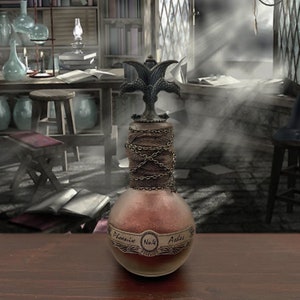 Puede incluir: Una botella de vidrio con un líquido marrón en su interior. La botella tiene una tapa de metal con un diseño de fénix de doble cabeza. La etiqueta dice "Phoenix No. 4 Ashes".