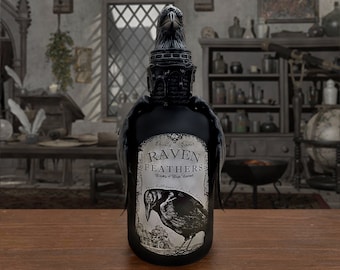 Peut inclure: Une bouteille en verre noir avec un motif de corbeau sur l'étiquette. L'étiquette indique "Raven Feathers" et "Ethicially Sourced" dans une police gothique. La bouteille a un bouchon en forme de corbeau noir.