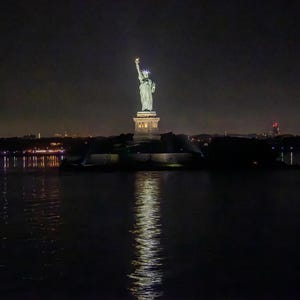 La Statua della Libertà di notte riflessa nell'acqua Fotografia stampata su tela o carta