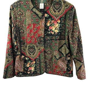 May include: A long-sleeved jacket featuring a patchwork design with various paisley and floral patterns in shades of green, red, black, and yellow. The jacket has a round neckline, a front button closure, and black trim along the edges and seams.