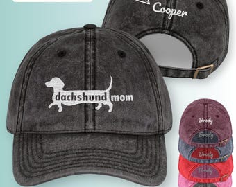 Puede incluir: Gorra de béisbol negra desgastada con "dachshund mom" bordado en la parte delantera. La parte trasera de la gorra se puede personalizar con el nombre de una mascota. Hay seis opciones de color disponibles.