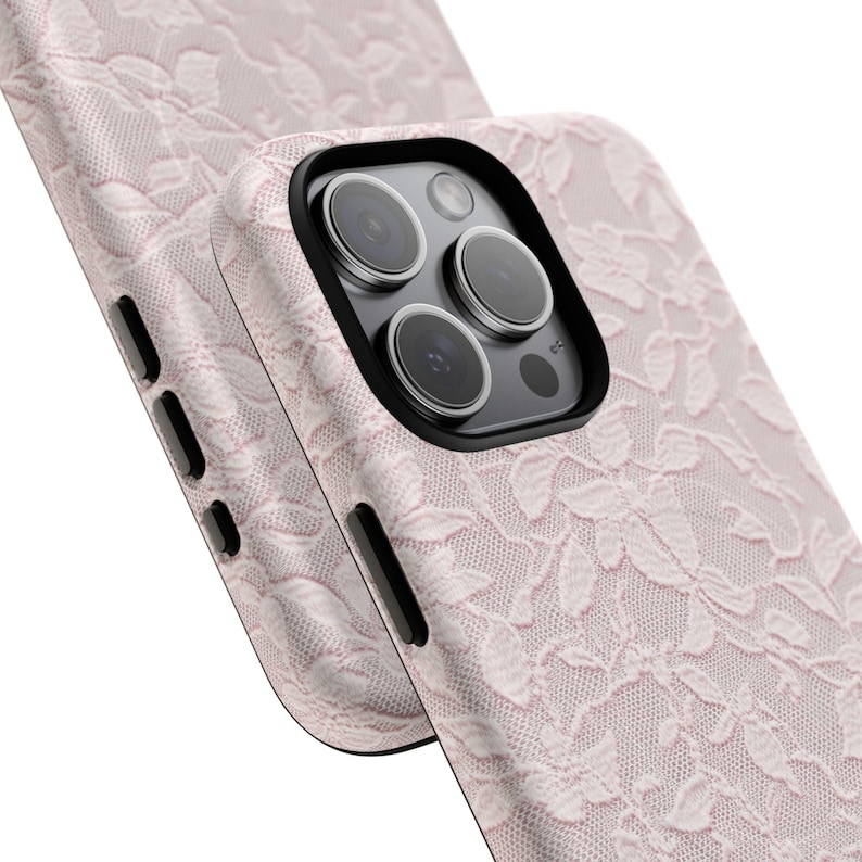 K&ouml;nnte beinhalten: Nahaufnahme von zwei rosa Handyh&uuml;llen mit einem zarten Spitzenmuster. Die H&uuml;llen haben einen schwarzen Kamerarahmen und Seitentasten. Das Design zeigt eine florale Spitzenschicht.