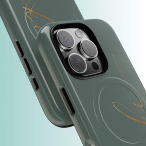 Pu&ograve; includere: Primo piano di due custodie per telefono verdi con un design a spirale dorato. Le custodie hanno una protezione per l'obiettivo della fotocamera nera. Le custodie per telefono sono probabilmente per uno smartphone.