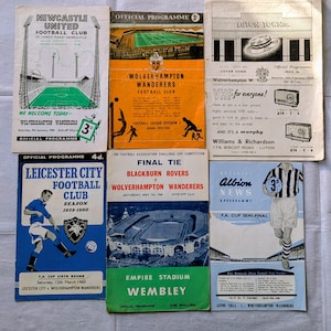 May include: A selection of vintage football match programmes. The programmes feature teams such as Newcastle United, Wolverhampton Wanderers, and Leicester City. The programmes are in various colours, including blue, orange, and green, with stadium and player illustrations.