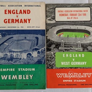 May include: Two vintage football match programs. The first program is for England versus Germany, December 1, 1954, at Wembley's Empire Stadium. The second program is for England versus West Germany, February 23, 1966, also at Wembley.
