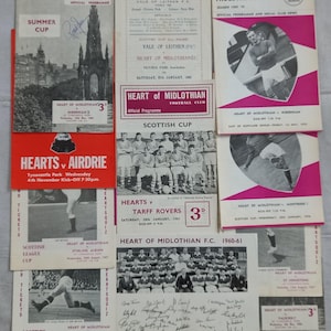 Könnte beinhalten: Eine Sammlung von Vintage-Programmen und Tickets des Heart of Midlothian Football Club. Die Artikel zeigen Teamfotos, Spielinformationen und das Logo des Clubs. Die Farben sind hauptsächlich Rot, Weiß und Schwarz, mit einigen Programmen, die Actionaufnahmen zeigen.