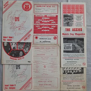 May include: A selection of vintage Scottish football programmes and magazines, predominantly red and white. The printed ephemera includes team lineups, adverts, and season details. The publications are from the 1970s and feature the Hamilton Accies team.