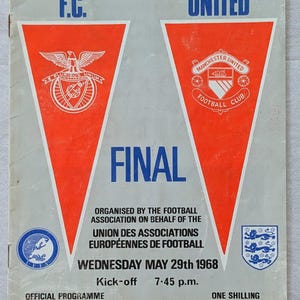 Op de afbeelding: Vintage wedstrijdprogramma voor de finale van de Europacup I 1968 tussen Benfica F.C. en Manchester United. Rood en wit omslag met teamlogo's en de naam Wembley Empire Stadium.