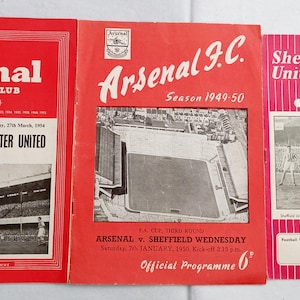 Könnte beinhalten: Drei alte Fußball-Spielprogramme mit rot-weißen Einbänden. Das linke Programm ist für Arsenal gegen Manchester United im Jahr 1954. Das mittlere Programm ist für Arsenal gegen Sheffield Wednesday im Jahr 1950. Das rechte Programm ist für Sheffield United.