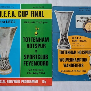 May include: Two vintage U.E.F.A. Cup Final souvenir programs. The first, from the 1973-74 season, features Tottenham Hotspur vs. Sportclub Feyenoord. The second, from 1971-72, shows Tottenham Hotspur vs. Wolverhampton Wanderers. Both programs have a blue, green, and yellow color scheme.
