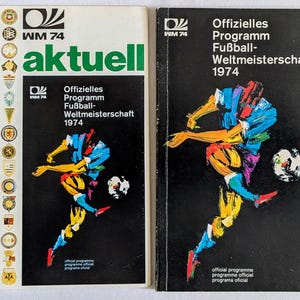 May include: Two vintage soccer program books from the 1974 FIFA World Cup. The covers feature a colorful illustration of a soccer player kicking a ball. One cover is white with green text, the other is black.