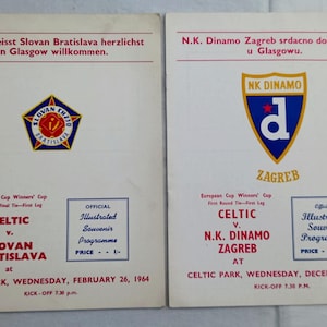 Könnte beinhalten: Zwei alte Fußball-Programmhefte aus dem Celtic Park. Das linke Heft zeigt das Wappen von Slovan Bratislava für ein Spiel von 1964. Das rechte Heft zeigt das Wappen von NK Dinamo Zagreb für ein Spiel von 1963, beide auf weißem Papier gedruckt.