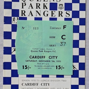 May include: A vintage football match ticket for a Queens Park Rangers game against Cardiff City, dated November 7th, 1970. The ticket has a blue and white checkered design and includes the match details and price of 15/-.