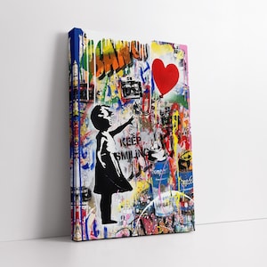 Puede incluir: Una obra de arte estilo Banksy sobre lienzo. La imagen presenta una silueta negra de una niña que alcanza un globo rojo en forma de corazón. El fondo es una vibrante mezcla de arte graffiti con las palabras "KEEP SMILING".