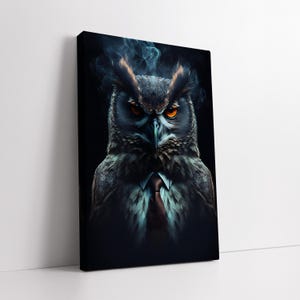 Op de afbeelding: Een canvas print met een gedetailleerde illustratie van een uil in pak en stropdas. De uil heeft intense oranje ogen en wordt omgeven door slierten blauwe rook tegen een donkere achtergrond. Het kunstwerk is gemonteerd op een zwart canvas.