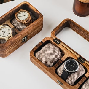 Unique Wood watch box for watches, featuring rounded corners, a sleek, treated wood texture, and a glass lid for constant visibility. Customize the glass lid with your own engraving.