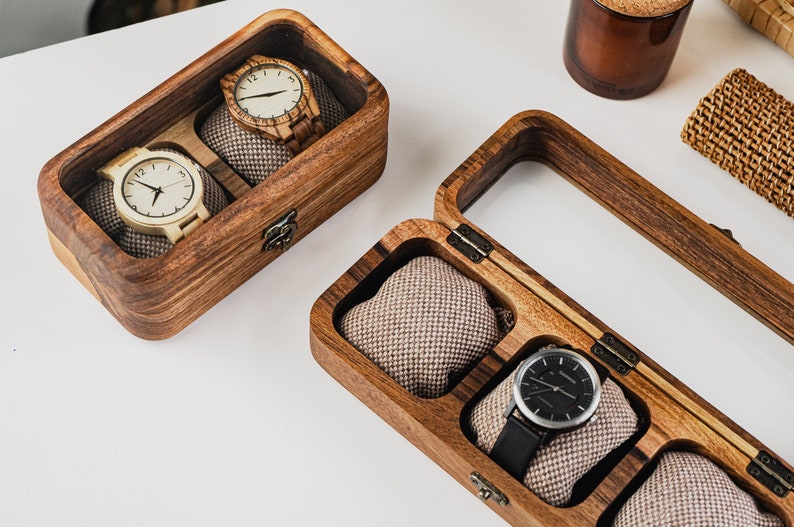 Unique Wood watch box for watches, featuring rounded corners, a sleek, treated wood texture, and a glass lid for constant visibility. Customize the glass lid with your own engraving.