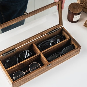 Handcrafted wooden sunglasses case for 4 glasses with a stylish design and glass lid so you can always see your glasses, even when box is closed. Each compartment has a felt lining to protect your glasses from scratching.