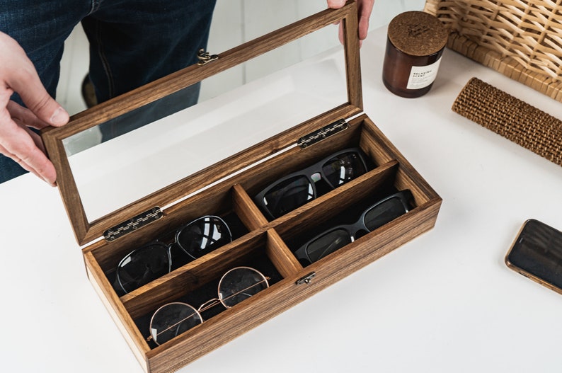Handcrafted wooden sunglasses case for 4 glasses with a stylish design and glass lid so you can always see your glasses, even when box is closed. Each compartment has a felt lining to protect your glasses from scratching.