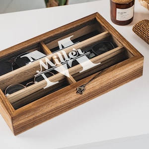 Handcrafted wooden sunglasses case for 6 glasses with a stylish design and big custom engraving in the center of the glass lid. Each compartment has a felt lining to protect your glasses from scratching.