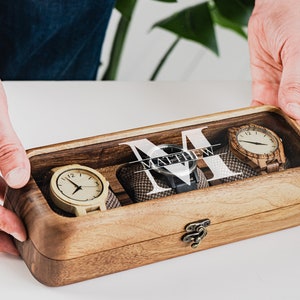 Unique Wood watch box for watches, featuring rounded corners, a sleek, treated wood texture, and a glass lid for constant visibility. Customize the glass lid with your own engraving.