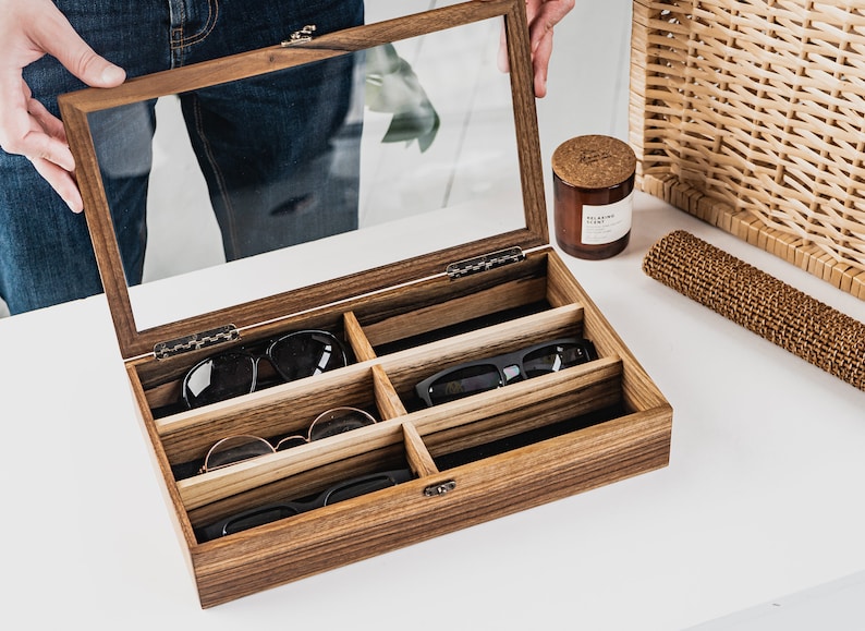 Handcrafted wooden sunglasses case for 6 glasses with a stylish design and glass lid so you can always see your glasses, even when box is closed. Each compartment has a felt lining to protect your glasses from scratching.