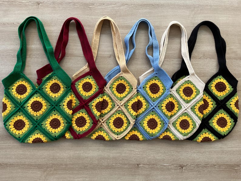 May include: Six crocheted tote bags with sunflower designs in various colors, including green, red, beige, blue, white, and black.