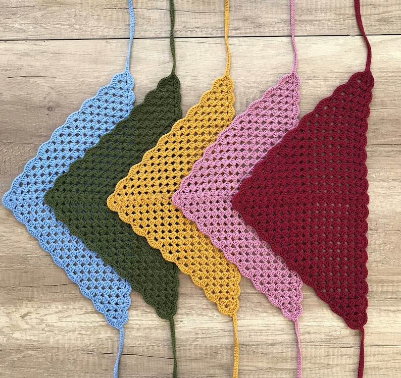 May include: Five crocheted triangle scarves in different colours: light blue, dark green, yellow, pink and burgundy.