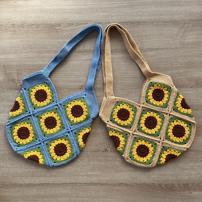 May include: Two crocheted tote bags with sunflower designs. One bag is blue and the other is beige.