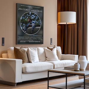 Könnte beinhalten: Ein gerahmtes Poster mit schwarzem Hintergrund und einem kreisförmigen Bild eines Mannes, der auf einem Sims sitzt. Das Poster trägt oben den Text "Cole 2014 Forest Hills Drive".