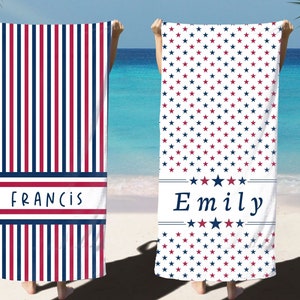 May include: Two beach towels with red, white, and blue stripes and stars. One towel has the name "Francis" printed on it, and the other towel has the name "Emily" printed on it.