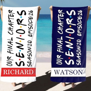 Puede incluir: Se muestran dos toallas de playa, una blanca y otra azul marino. La toalla blanca tiene una banda roja en la parte inferior con el nombre "RICHARD". La toalla azul marino tiene una banda blanca con el nombre "WATSON". Ambas toallas muestran el texto "OUR FINAL CHAPTER SENIORS SEASON:20 EPISODE:26".
