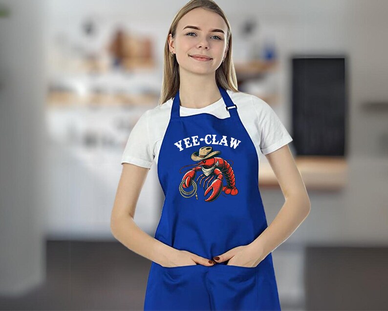 May include: A blue apron with a white graphic of a lobster wearing a cowboy hat and the text "YEE-CLAW".
