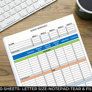 May include: A stack of budget worksheets on a wooden desk, with a white keyboard and a mug of coffee in the background. The worksheets have sections for income, expenses, and debt, with columns for weeks 1-5. Text at the bottom reads: 50-SHEETS- LETTER SIZE-NOTEPAD-TEAR & FILE.