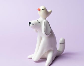 BANTU ENTE I white porcelain handmade dog with with yellow duck. Cute ceramic decoration for any occasion.