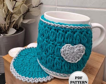 May include: Teal crochet mug cozy with a gray heart design and a matching teal crochet coaster.  The cozy is on a white mug with a gray trim.  PDF PATTERN.