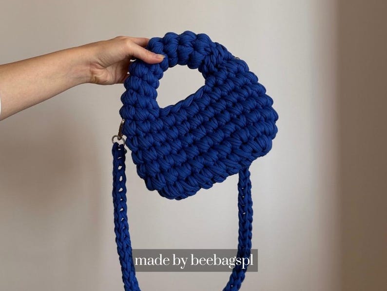 Może przedstawiać: Ręcznie robiona, kr&oacute;lewska niebieska torebka z grubym, teksturowanym wzorem dzianiny. Torebka posiada zaokrąglony uchwyt i odpinany pasek na ramię. Widoczny jest tekst "made by beebagspl".