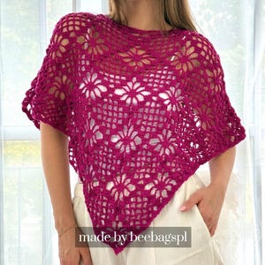 May include: A magenta crochet top featuring a repeating floral motif pattern with an openwork design. The garment has a wide, loose fit with short sleeves and a pointed hemline. The text "made by beebagspl" is visible at the bottom center.