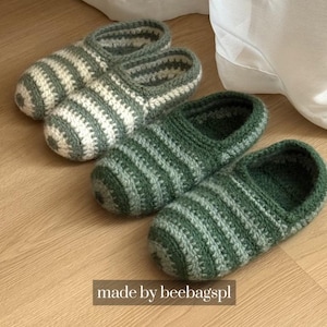 May include: Two pairs of handmade crochet slippers in green and white stripes. The slippers are displayed on a light brown wooden surface. The text "made by beebagspl" is visible at the bottom.