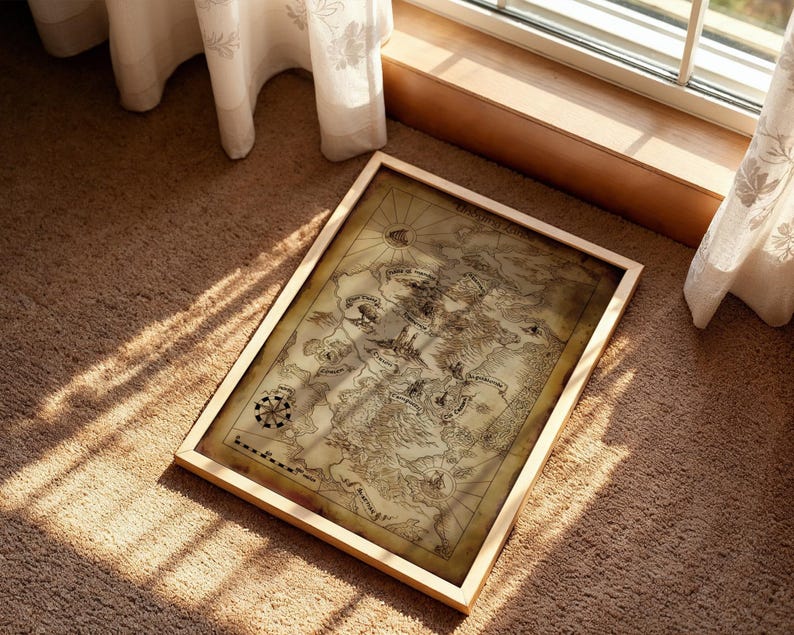 May include: A framed vintage map with a light wood frame. The map displays detailed illustrations of landmasses, a compass rose, and other cartographic elements. The map is resting on a brown carpet, with sunlight streaming in from a nearby window.