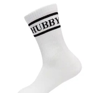 May include: White crew sock with the word "HUBBY" in black block letters. The sock has two black stripes at the top. The sock is made of a soft, comfortable material.