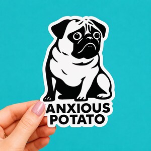May include: A die-cut sticker featuring a black and white graphic illustration of a pug dog with wide, worried eyes. Below the dog, the text ANXIOUS POTATO is printed in bold, black, sans-serif capital letters against a white background.