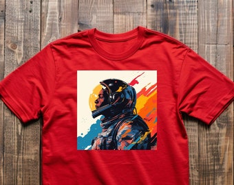 May include: Red t-shirt with a colorful graphic of an astronaut wearing a helmet. The astronaut is facing to the left and the background is a mix of blue, yellow, orange, and white.