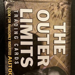 May include: A black and white trading card pack with the text "The Outer Limits" and "Trading Cards" on the front. The pack has a picture of a man's face on the front. The text "Look for randomly inserted autograph cards" is on the left side of the pack. The text "9 Cards" is on the right side of the pack.