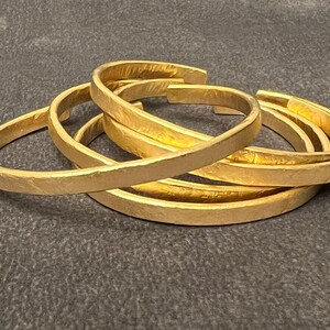 A hammered handmade cuff bracelet, brass base metal, matt finish, 18k gold plated.